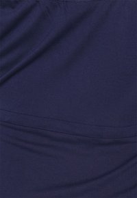 Navyblauw stof met een zachte textuur, met een gladde afwerking en subtiele stretch. Het materiaal is licht en licht elastisch.