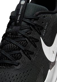 Scarpe Nike Pegasus Trail 5 in mesh nero, con un logo swoosh bianco, tomaia testurizzata e lacci neri, con il marchio sulla linguetta.