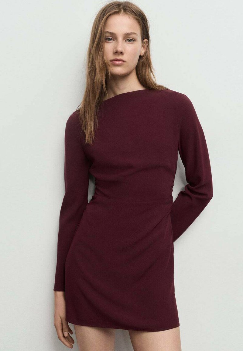 Vestido burdeos de manga larga con silueta ajustada y detalle fruncido en la cintura, confeccionado en una tela suave, de largo hasta la rodilla, diseño minimalista.