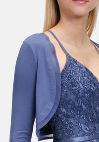 Niebieska wieczorowa sukienka z misternym haftem kwiatowym, przezroczystymi rękawami i regulowanymi ramiączkami. Miękka tkanina z dopasowanym gorsetem i zwiewnym krojem.