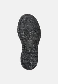Svart gummisula med ett texturerat mönster, som har en logotyp och storleksinformation präglad i mitten. Halkfri mönstring för bra grepp.