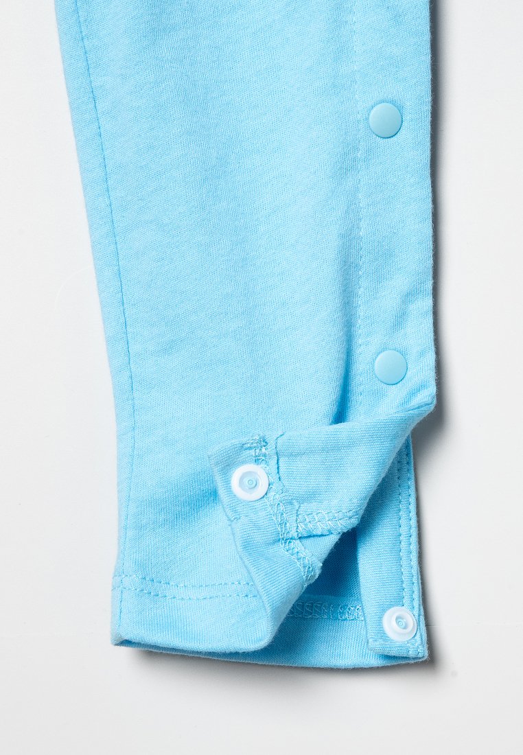 Jasnoniebieski bawełniany rękaw z zagiętym brzegiem, wyposażony w dwa zatrzaski. Gładka tekstura i prosty design z estetycznym wykończeniem.