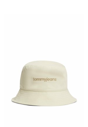 Beige bucket hat met geborduurd "tommyjeans"-logo centraal aan de voorkant, met gestikte rand.