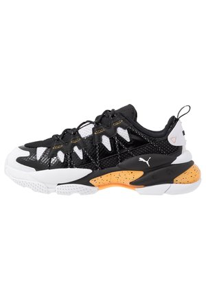 Black and white athletic sneaker with orange speckled midsole, mesh and synthetic upper, lace-up design, and Puma logo on the side.