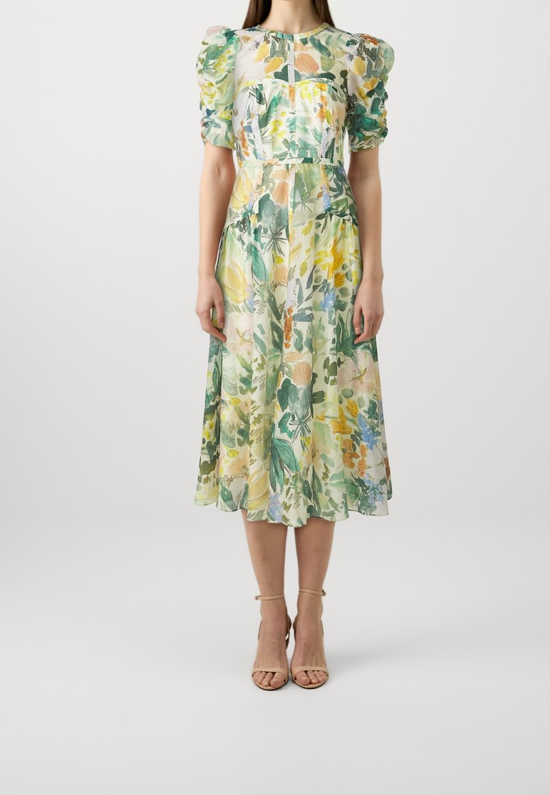 Blommig midiklänning i lätt tyg med gröna, gula och blå mönster, puffärmar och en figurnära midja.