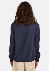Granatowy sweter z ribbami na mankietach i dole, wykonany z miękkiego materiału, z klasycznym okrągłym dekoltem i luźnym krojem.