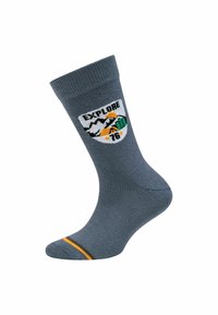 Calzettone grigio con risvolto, featuring una colorata patch di montagne, sole, albero e testo "EXPLORE 76", oltre a strisce arancioni e marroni sulla punta.