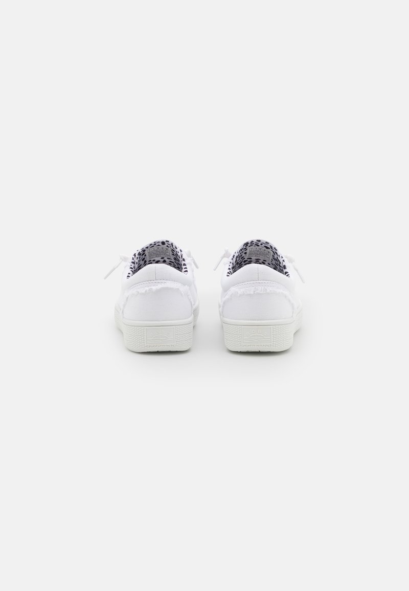 Sneaker bianche in tela con suola di gomma testurizzata, caratterizzate da un bordo posteriore sfrangiato e un rivestimento in tessuto a motivi in bianco e nero.