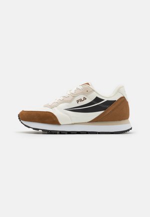 Sneaker mit einem synthetischen Obermaterial in Creme, braunen Wildlederakzenten, schwarzen Seitenstreifen und einer weißen Zwischensohle. Baumwollsenkel und Gummisohle.