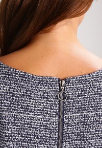 Navy- und weißes, strukturiertes Kleid mit einem unsichtbaren Reißverschluss am Rücken und einem runden Ziehband. Glattes, gewebtes Material mit einem strukturierten Design.