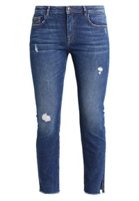 Vaqueros de denim azul oscuro con un ajuste slim, detalles desgastados y pequeñas deshilachaduras en las rodillas. Presentan un diseño clásico de cinco bolsillos.
