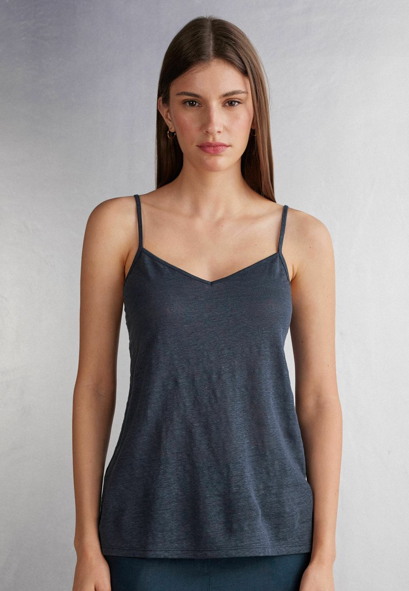 Navy blauwe camisole met dunne verstelbare banden, v-hals en een zachte, lichte stof, met een subtiele gemêleerde textuur.