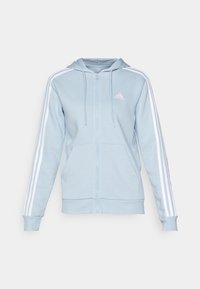 Sudadera con cremallera de color azul claro, hecha de tela suave, con capucha ajustable, bolsillos frontales y diseño de tres rayas blancas en las mangas.