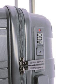 Maleta rígida de color gris con superficie texturizada, cremalleras dobles, un candado de combinación y un asa telescópica.