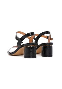 Zwarte hakken sandalen met een textuur van nep slangenleer. Kruisbanden met een verstelbare gesp, blokhak voor stabiliteit.