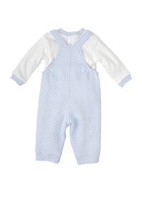 Pantalones de mezclilla acolchados en azul claro con una camiseta de manga larga blanca. Presenta cierres a presión y puños acanalados, proporcionando un diseño texturizado y en capas.