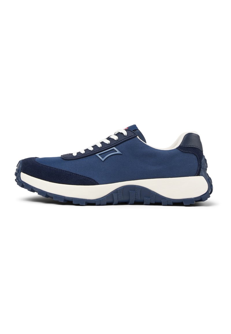 Scarpa da ginnastica blu navy con tomaia in tessuto morbido, dettagli in suede e una robusta intersuola bianca spessa, dotata di una suola in gomma testurizzata e resistente.
