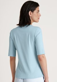 Lichtblauwe, korte mouwen t-shirt met een gladde textuur en een ronde halslijn. Heeft een getailleerde vorm, zonder zichtbare patronen of versieringen.