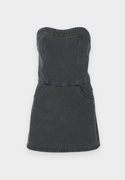 Αόρατο τζιν φόρεμα σε σκούρο γκρι χρώμα, με εφαρμοστό κορμό, δύο μπροστινές τσέπες και ευθεία μεριά φούστας με ορατές ραφές.