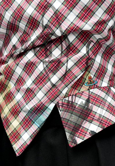 Lyhythihainen ruutupaita, jossa on punaisen, valkoisen ja vihreän sävyjä sekä graafinen päällepainatus. Paidassa on pieni kirjailtu kuvio helmassa.