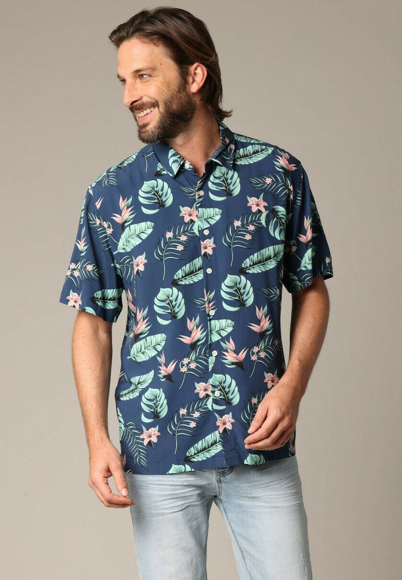 Korte mouwen marineblauwe shirt met grote groene bladeren en roze bloemen. Lichtgewicht stof, knoopsluiting en getailleerde pasvorm.