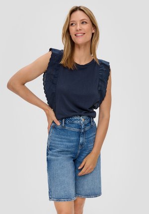Dunkelblaues Oberteil mit gerüschten, gewellten Stanzärmeln, kombiniert mit hellblauen Denim-Shorts. Lässiges Design mit taillierter Passform und lockerer Silhouette.