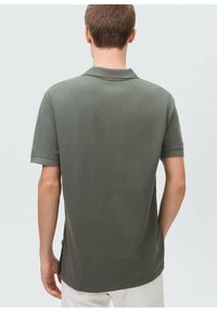 Tmavě zelené polo tričko s klasickým límcem, krátkými rukávy a rovnými lemy. Vyrobeno z texturované bavlněné tkaniny.