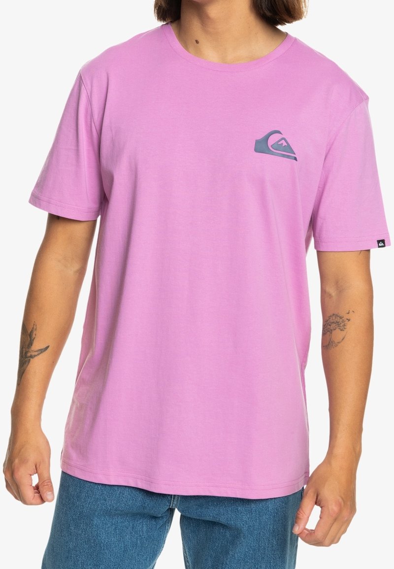 T-shirt en coton rose à manches courtes, avec un petit logo gris sur le côté gauche de la poitrine. Le tissu a une texture lisse et légère.
