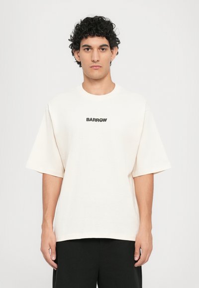 Camiseta de algodón de gran tamaño en color crema con un logotipo negro "BARROW" en el pecho, con mangas cortas y un cuello redondo.