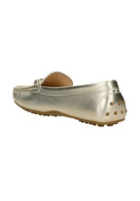 Mocassino slip-on in oro metallizzato con punta arrotondata, una texture in pelle liscia e una suola in gomma caratterizzata da piccoli chiodi circolari sul tallone.