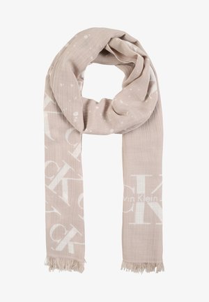 Lysebeige halstørklæde med subtilt hvidt Calvin Klein logo print og frynser i enderne, løst viklet i en løkke.