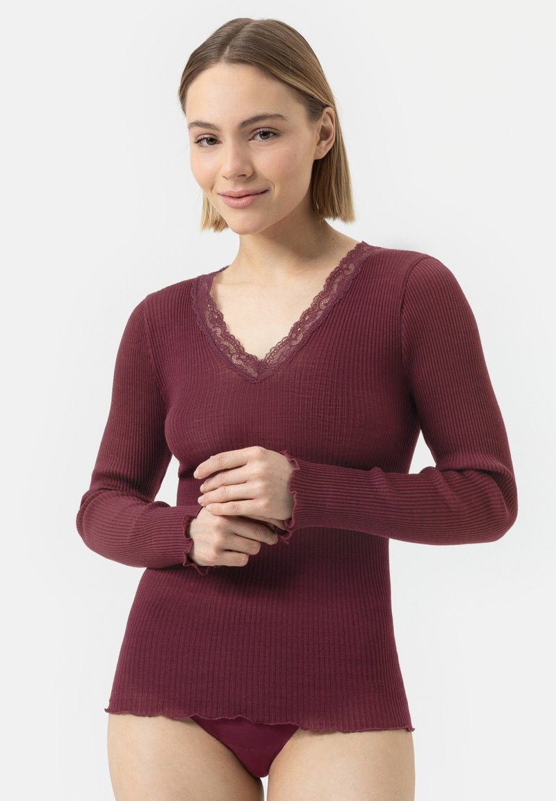 Haut long à manches en bourgogne avec un décolleté en V, des garnitures en dentelle et un ourlet festonné. Texture lisse et design ajusté, associé à des culottes assorties.