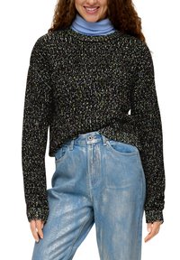 Zwarte trui met kleurrijke spikkels, lange mouwen en geribbelde manchetten, gelaagd over een lichtblauwe turtleneck, in combinatie met lichtblauwe spijkerbroek.