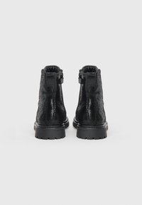 Bottes de cheville noires texturées avec une finition mate, vue de derrière. Caractéristiques d'une semelle robuste et d'une couture contrastante. Deux languettes de tirage au niveau du col.