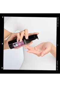 Produkt do włosów Redken Labs 400 w czarnej butelce z pompką, z różową etykieta, dozujący przezroczystą ciecz do dłoni.