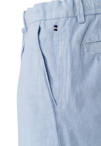 Light blue linen trousers with a textured surface, featuring side pockets and a small stitched brand accent near the waistband.