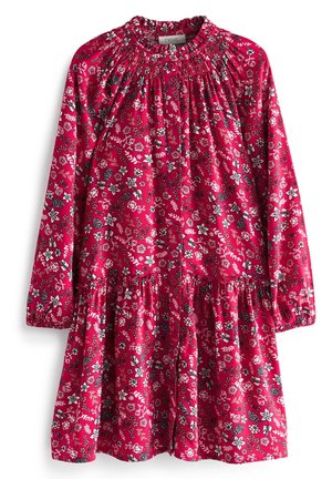 Robe rouge à manches longues avec motifs floraux blancs et noirs, encolure froncée, boutonnée sur le devant et poignets élastiques.