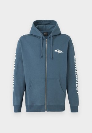 Zippered hoodie in dark blue cotton blend, features a kangaroo pocket, ribbed cuffs, and white graphic on the left chest and sleeve.