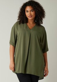 Olivgrünes Blusenshirt mit kurzen Ärmeln, V-Ausschnitt und Faltendetail an der Vorderseite, aus leichtem, glattem Stoff, mit lässiger Passform.