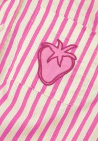 Striped shirt with pink and cream colors; features a pocket with a pink strawberry embroidery; smooth fabric with fine stitching details.