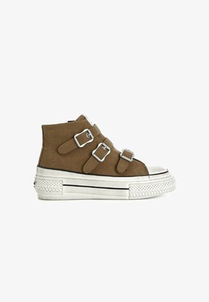 Brown suede high-top shoe with three adjustable silver buckles, white rubber sole, and textured toe cap. Black accent lines at the base.