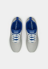 Egy szürke és kék Jack & Jones sportcipő pár, fehér fűzőkkel, felülnézetből, fehér háttéren.