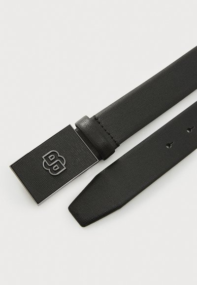 Ceinture synthétique noire avec une surface texturée, dotée d'une boucle en argent rectangulaire et de cinq trous ajustables pour la taille.