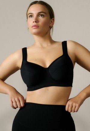Black underwire bra with textured cups and wide adjustable straps. The design includes a smooth band for support and a simple, clean silhouette.