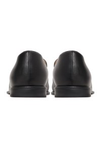 Black leather shoes with a smooth texture, round toe, low heel, and minimalistic design. Stitching details along the back.