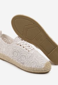 Des chaussures blanches à lacets avec un design brodé de fleurs, un tissu texturé, un bout rond et une semelle en corde naturelle avec un fond en caoutchouc pour une meilleure adhérence.