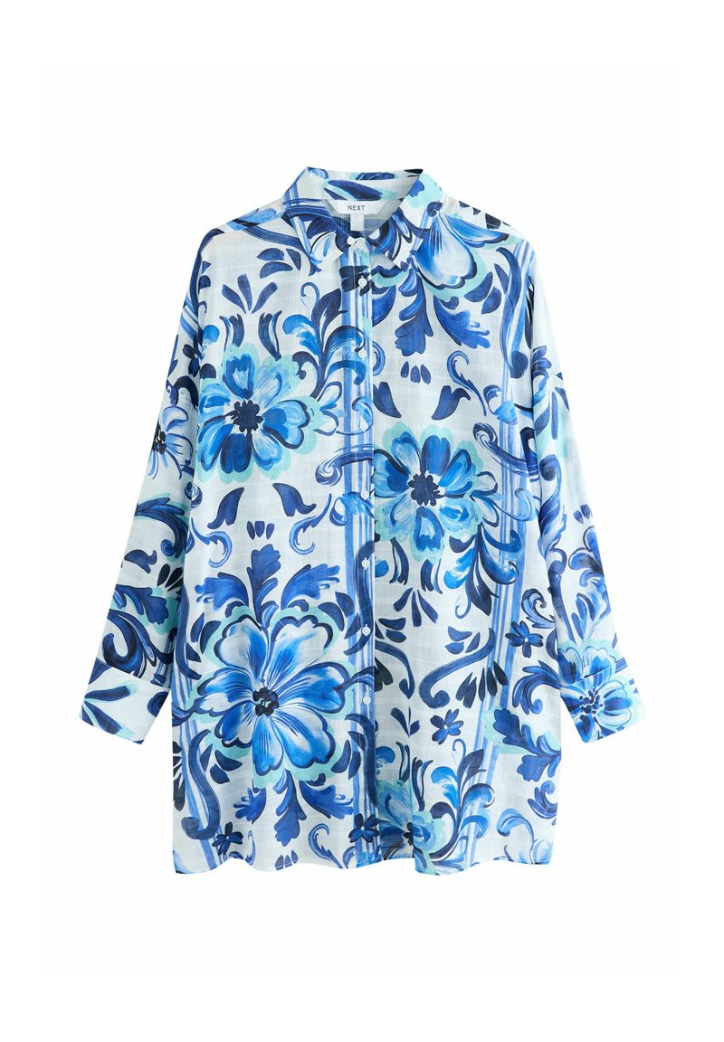 Cămașă cu mâneci lungi, cu guler și nasturi, având model floral alb și albastru. Țesătura prezintă mai multe nuanțe de flori albastre pe un fundal deschis.