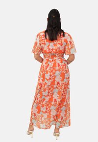 Maxikleid aus transparentem orangefarbenem Stoff mit floralem Muster, kurzen Ärmeln und elastischem Bund. Der Saum fällt elegisch bis zu den Knöcheln.