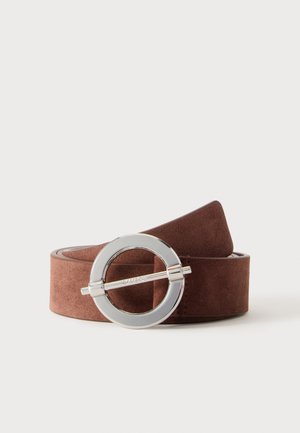 Ceinture en daim marron avec une boucle ronde en métal argenté comportant une barre horizontale au centre, placée sur un fond blanc uni.