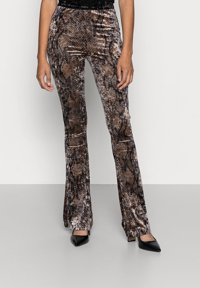 Ruskean käärmeennahkakuosiset, liehuvat housut, jotka on valmistettu pehmeästä, teksturoidusta kankaasta. Ominaisuuksiin kuuluu keskikorkea vyötärö ja hienovaraiset polvirei'ät, yhdistettynä mustiin, kärjettyihin korkokenkiin.